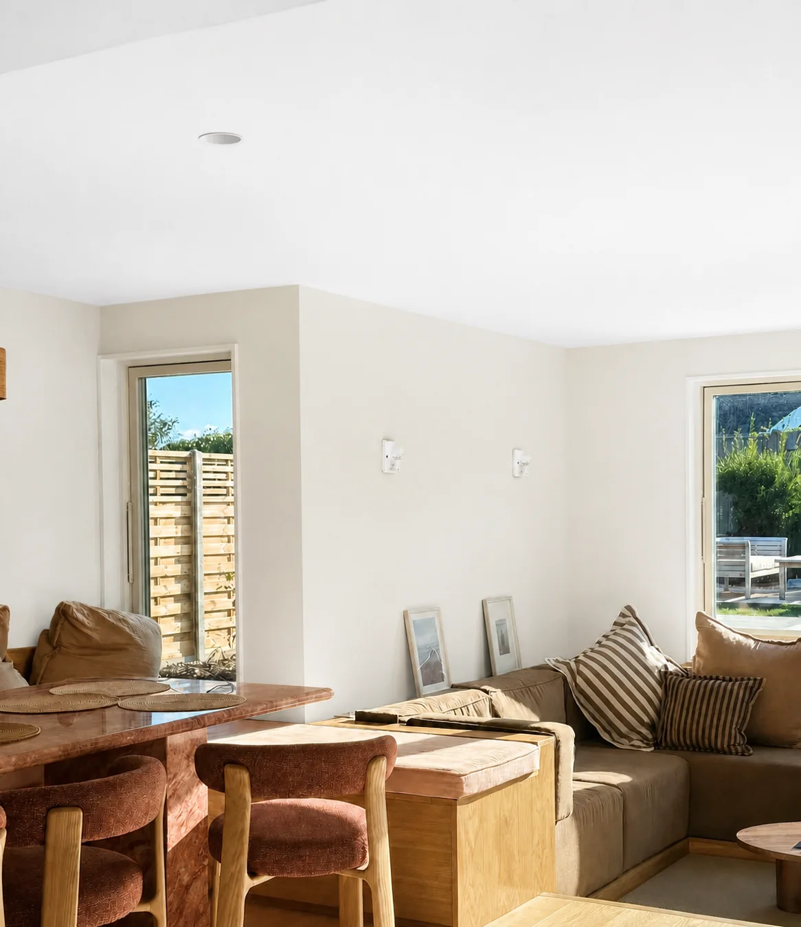 Completed open-plan living and dining room with warm finishes and garden views